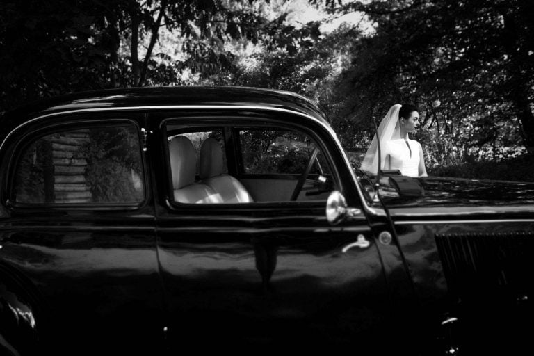 Gorgeous bride on background of stylish black car