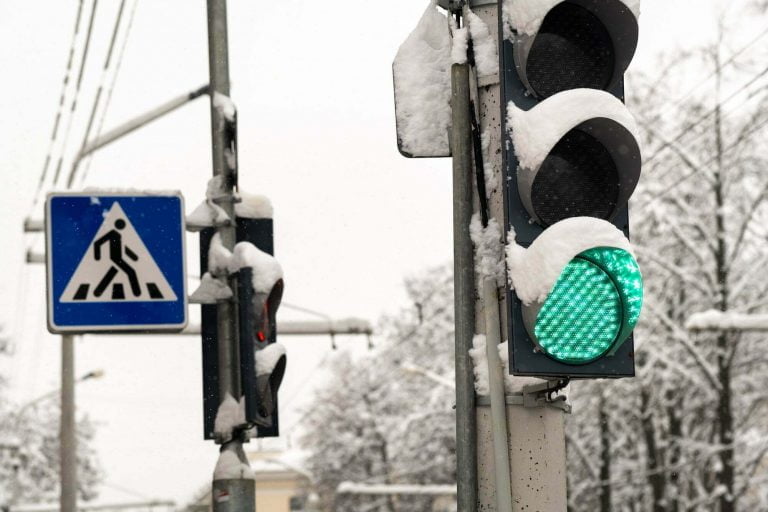 A working traffic light on a city street in winter.The traffic light is green