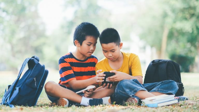Boys play online game on smartphone