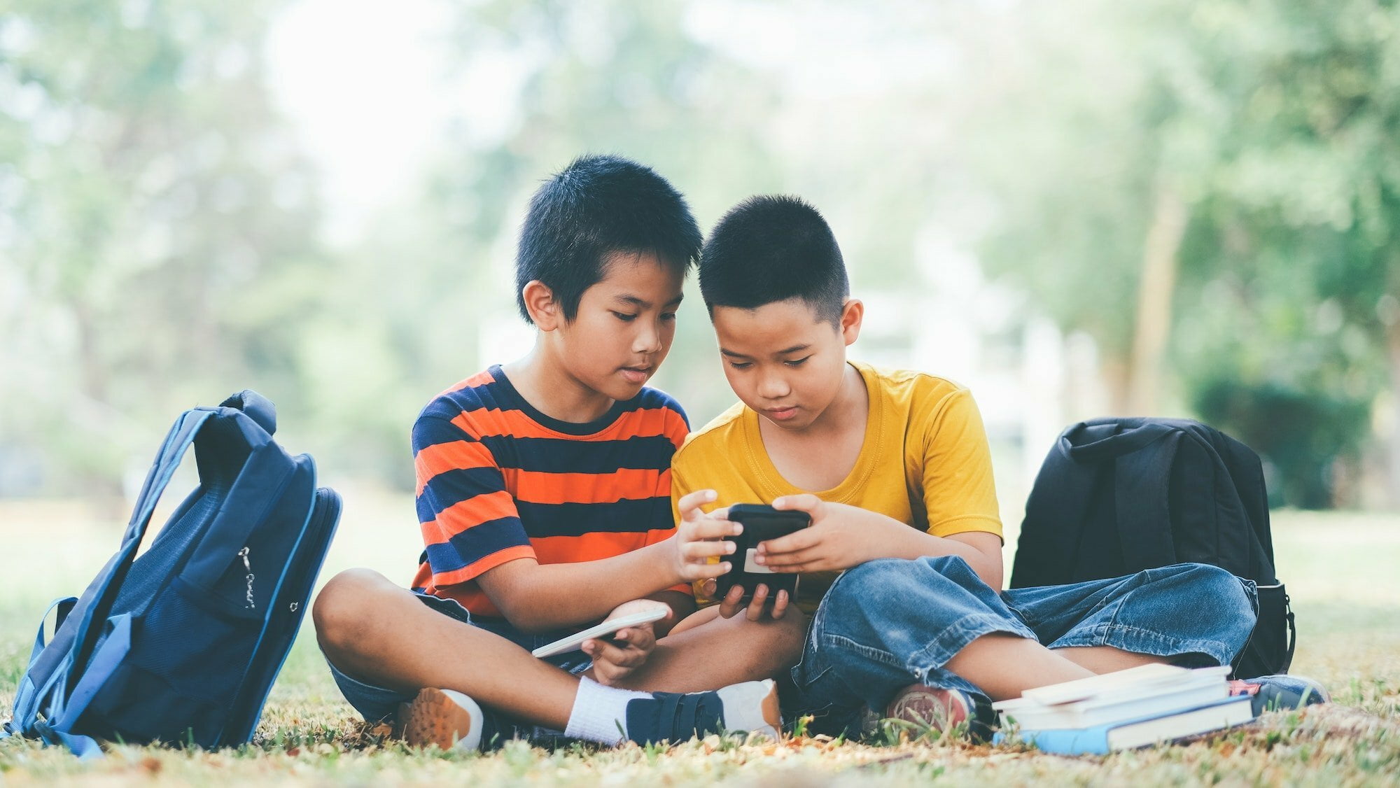 Boys play online game on smartphone