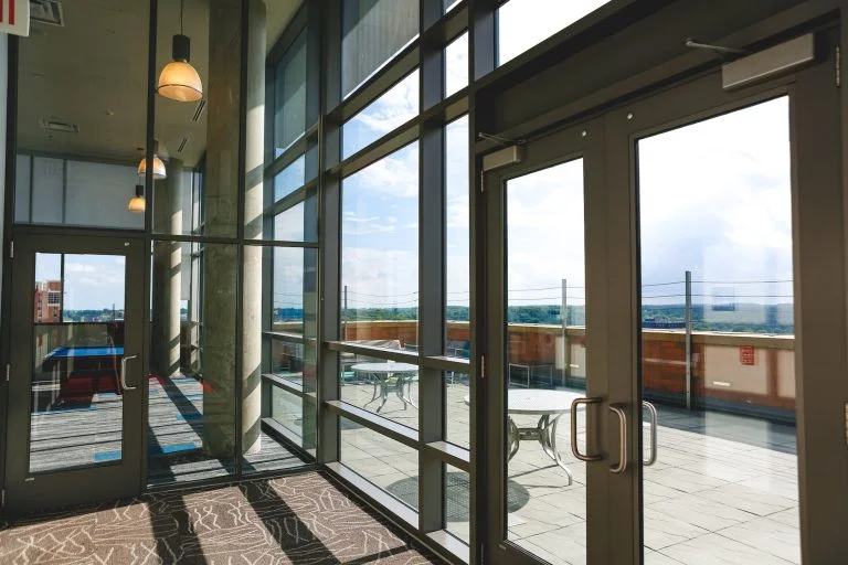 Glass doors and walls on the top floor of a chic college city apartment building downtown Ann Arbor