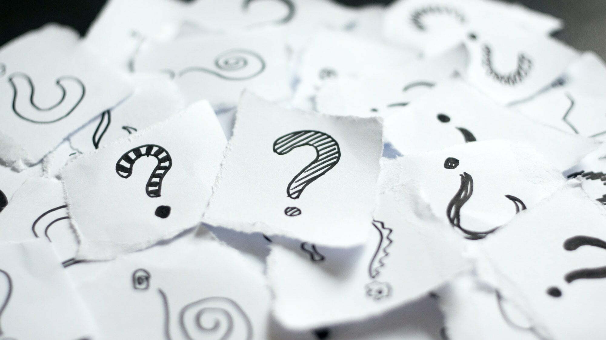 Many question marks on white papers. Doodle drawn question marks on scraps of paper. Choice