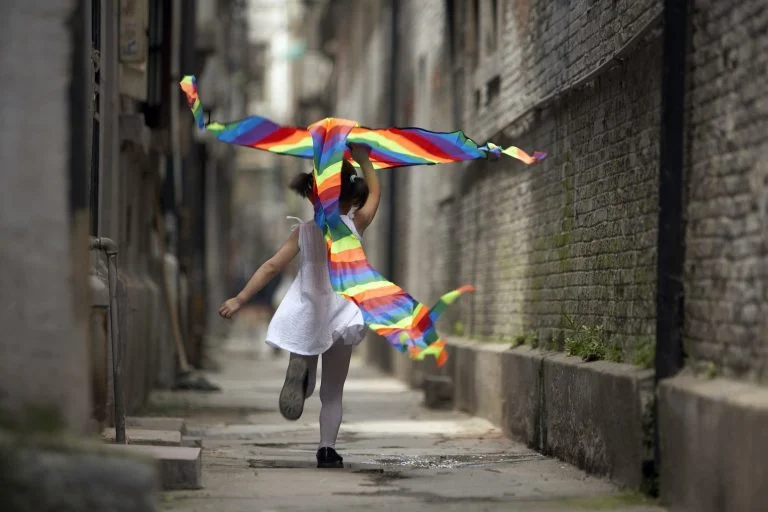 A child runs with a kite.